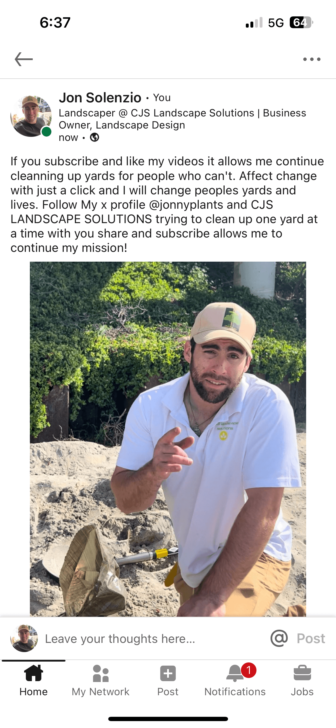 Man with a beard and cap making a peace sign outdoors, rocky background, wearing a white shirt.