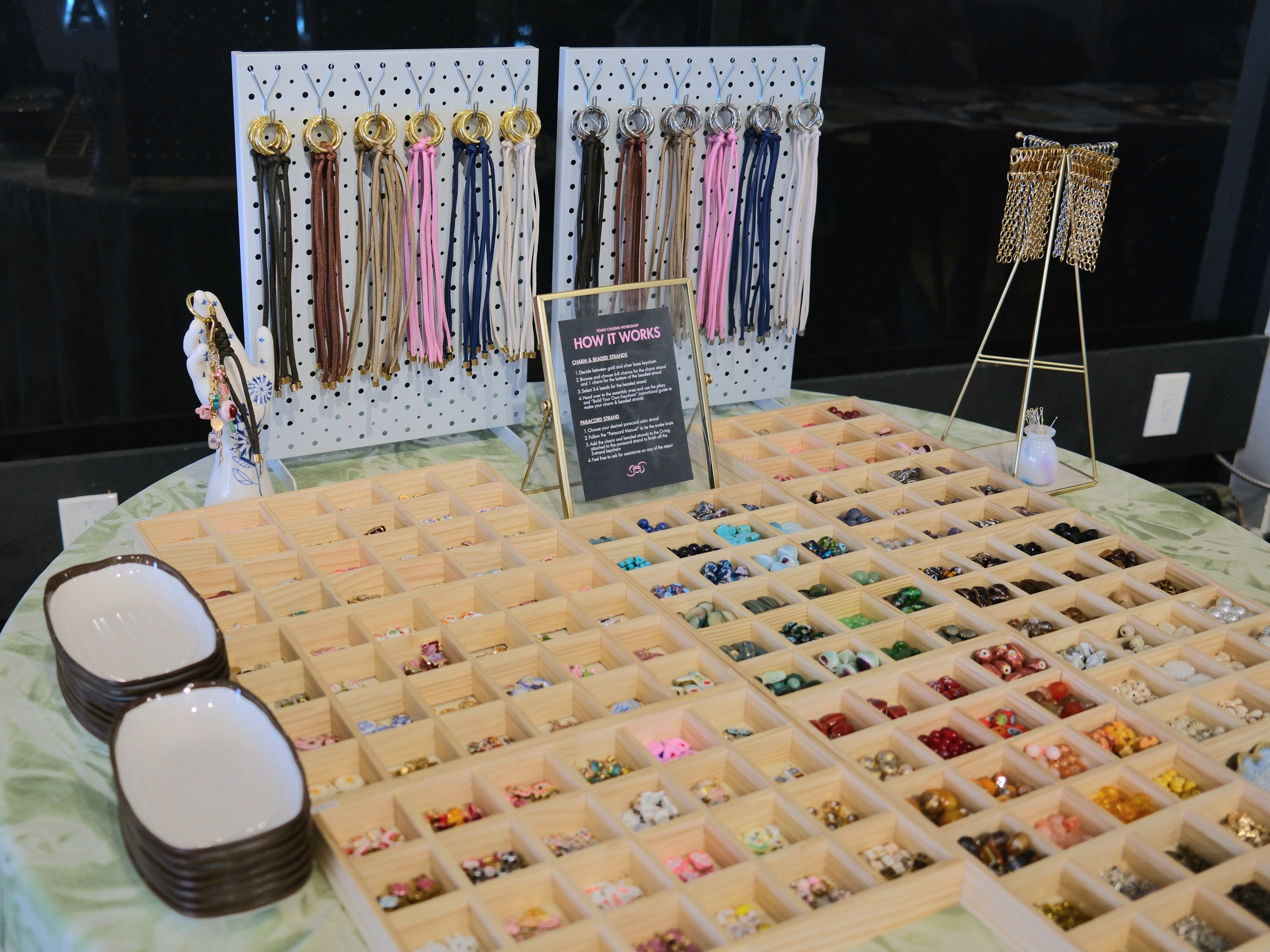 Display of jewelry and accessories on a table with organized compartments, hanging earrings, and decorative items, viewed from above.